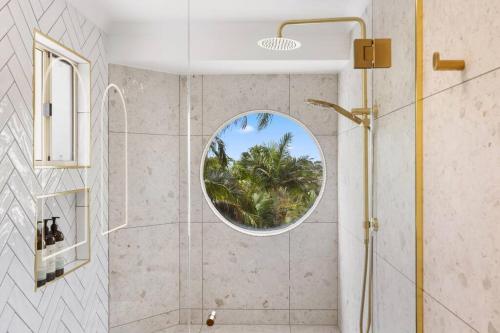 a bathroom with a shower with a round window at Coco Palms in Hervey Bay