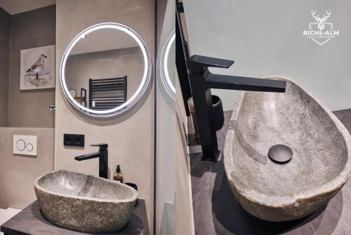 a bathroom with a large stone sink and a mirror at Chalet Gamsblüh in Oberstaufen