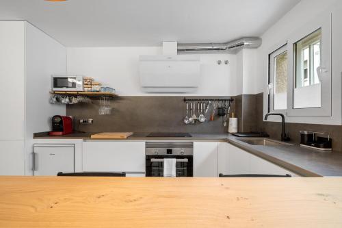 a kitchen with white appliances and a wooden counter top at Kaixo in Calafell