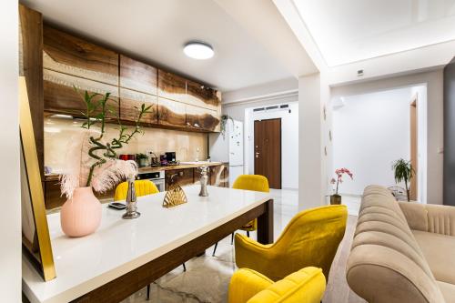 a living room with a table and yellow chairs at Il Magnifico in Voluntari