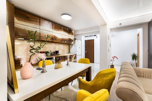 a living room with a table and yellow chairs at Luxury Ambiance in Voluntari
