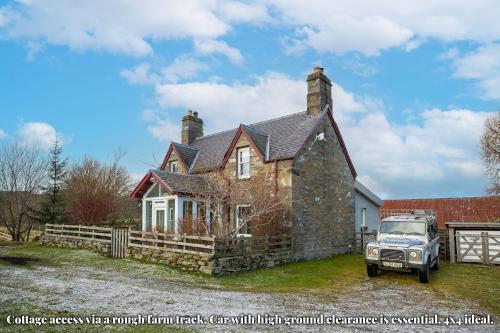 a house with a truck parked in front of it at Errichel House and Cottages in Aberfeldy