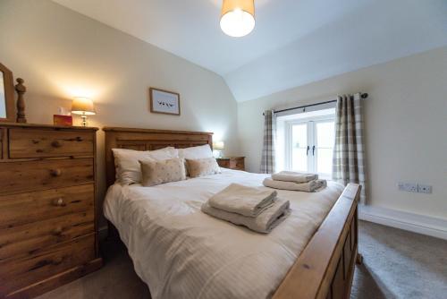 a bedroom with a large bed with two towels on it at Dale End Cottage, Brassington in Brassington