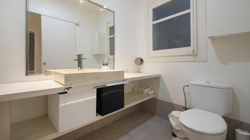 uma casa de banho com um WC, um lavatório e um espelho. em TarracoHomes, TH37 Apartamento Sant Agusti em Tarragona