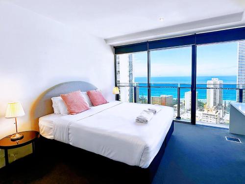 a bedroom with a large bed and a large window at Circle On Cavill Surfers Paradise Apartments-Holiday Paradise in Gold Coast