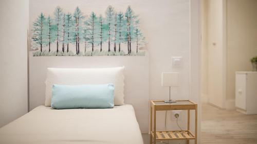 um quarto com uma cama e um quadro na parede em TarracoHomes, TH37 Apartamento Sant Agusti em Tarragona