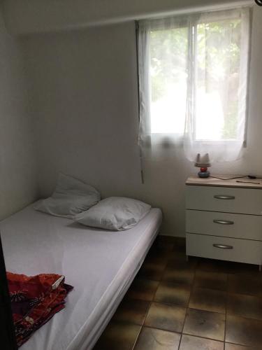 une chambre avec un lit, une commode et une fenêtre dans l'établissement T2 St pierre la mer, à Fleury