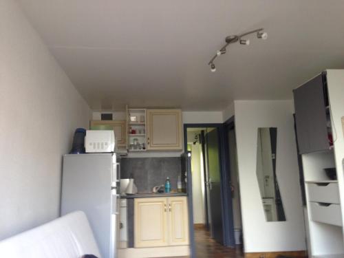 Cette chambre comprend une petite cuisine avec un réfrigérateur blanc. dans l'établissement T2 St pierre la mer, à Fleury
