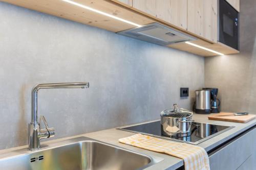 a kitchen with a sink and a counter top at Les Ciases Chalets Dolomites Apt 6 in San Vigilio Di Marebbe