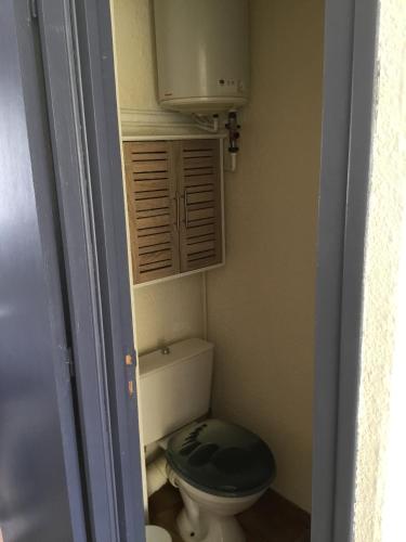 une petite salle de bains avec toilettes et siège noir dans l'établissement T2 St pierre la mer, à Fleury