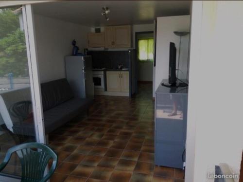 a living room with a couch and a kitchen at T2 St pierre la mer in Fleury