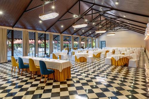 ウダイプールにあるAranya Vilasの白いテーブルと椅子が備わる宴会場