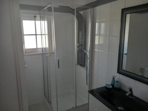 La salle de bains est pourvue d'une douche, d'un lavabo et d'un miroir. dans l'établissement Sea Moments mar à vista, à Portimão