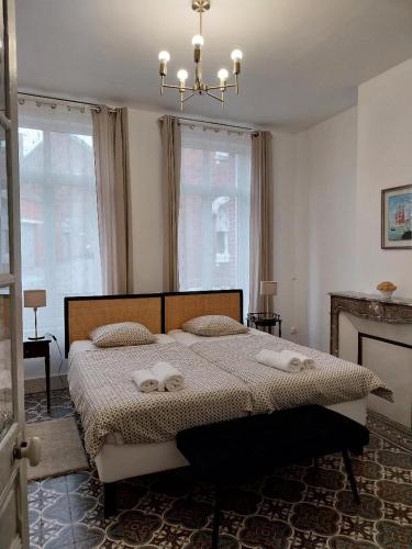 une chambre avec un lit avec deux serviettes dessus dans l'établissement La Maison de Léonie, à Péronne