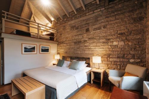 a bedroom with a bed and a brick wall at Aristi Mountain Resort in Aristi