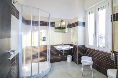a bathroom with a shower and a sink and a tub at Hotel Duca di Kent in Cesenatico