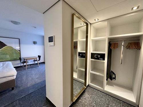 um quarto com um espelho, uma cama e uma secretária em AvidonApartments em Dusseldorf