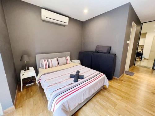 a bedroom with a bed with a black cross on it at [PROMO]Connected train 1 Bedroom (ABOVE MALL)6 in Kuala Lumpur