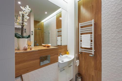 a bathroom with a sink and a mirror at White Pearl Apartment in Krakow