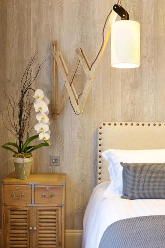 a bedroom with a bed and a table with a plant on it at 8 Beresford Street in Saint Helier Jersey