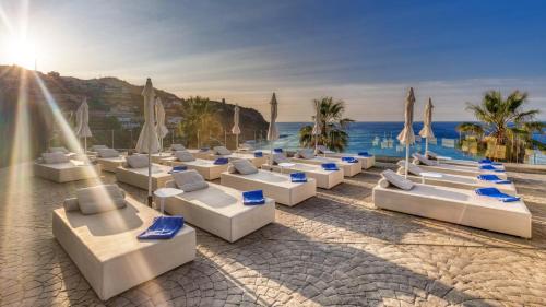 a beach with white lounge chairs and the ocean at Playacálida in Almuñécar