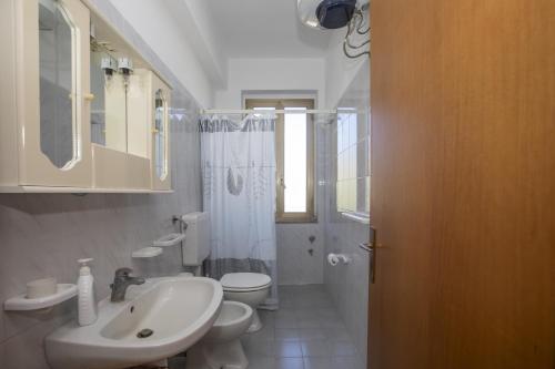 La salle de bains blanche est pourvue d'un lavabo et de toilettes. dans l'établissement Casa Al Mare San Giorgio, à Gioiosa Marea