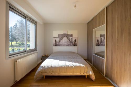 a bedroom with a bed and a large window at Le Cottage - circuit Bugatti - wifi - 8pers - Rêve au Mans in Le Mans