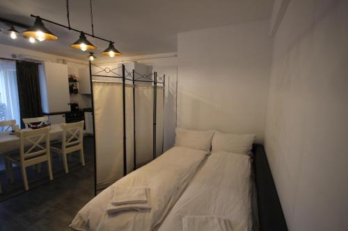 a small bedroom with a bed and a table at Apartment Francesca mit Parkplatz nähe Altstadt in Sibiu