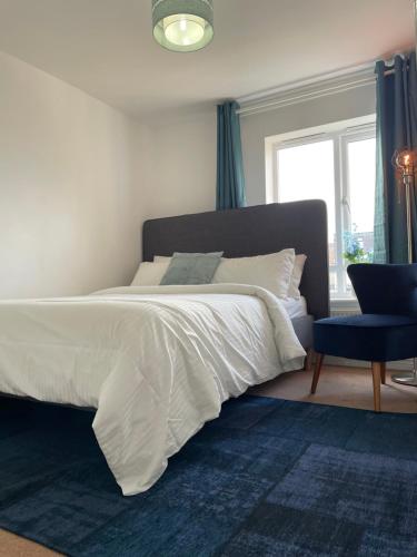een slaapkamer met een bed met een blauw tapijt en een raam bij Large Bed in a luxuriously furnished Guests-Only home, Own Bathroom, Free WiFi, West Thurrock in Grays Thurrock