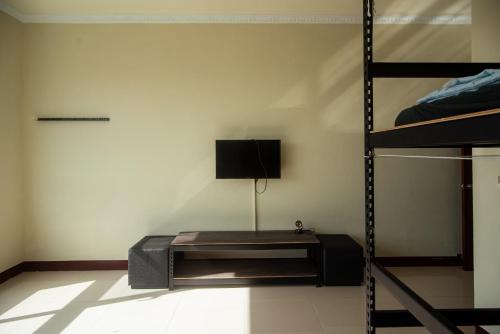 a room with a bunk bed and a television at Bare Foot Diving Hostel 2 in Hengchun