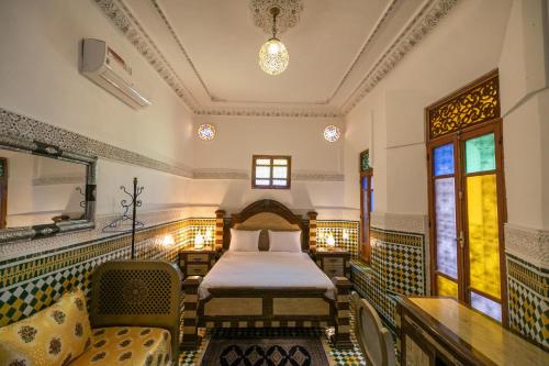 1 dormitorio con 1 cama, mesa y sillas en Dar Elinor en Fez