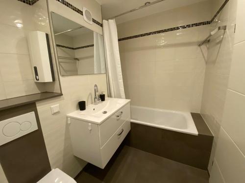 a bathroom with a sink and a toilet and a tub at SUITE4ME - Moderne Ferienwohnung I Küche I Balkon I Mainz-Kostheim in Wiesbaden