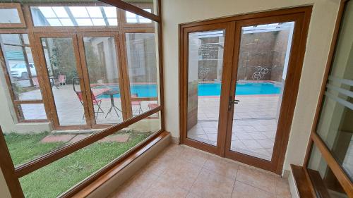 a room with a glass door with a view of a pool at Hotel Diego de Almagro Punta Arenas in Punta Arenas