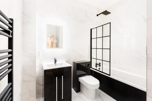 Baño blanco con aseo y lavamanos en Sydenham Place - Birmingham City Centre Jewellery Quarter - A Trio of Premium High End Town/Penthouses - 4 Bedrooms & Secure EV Parking en Birmingham