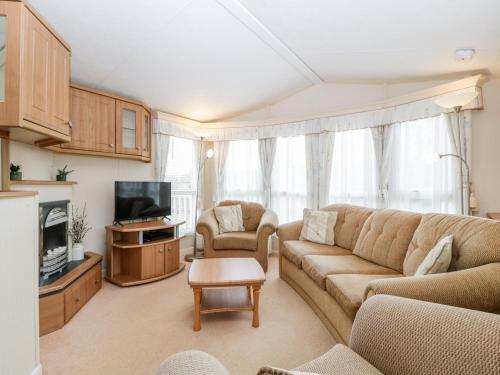 a living room with a couch and a tv at The Hideaway in Weymouth