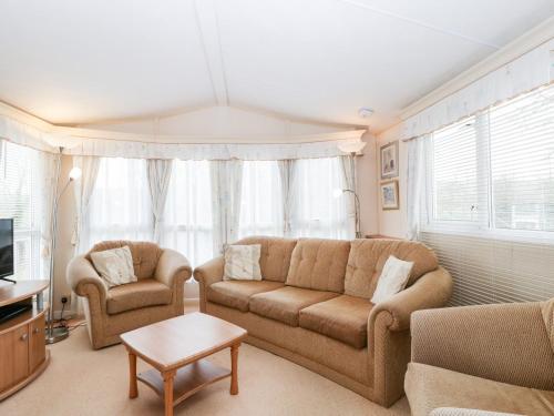 a living room with a couch and two chairs at The Hideaway in Weymouth