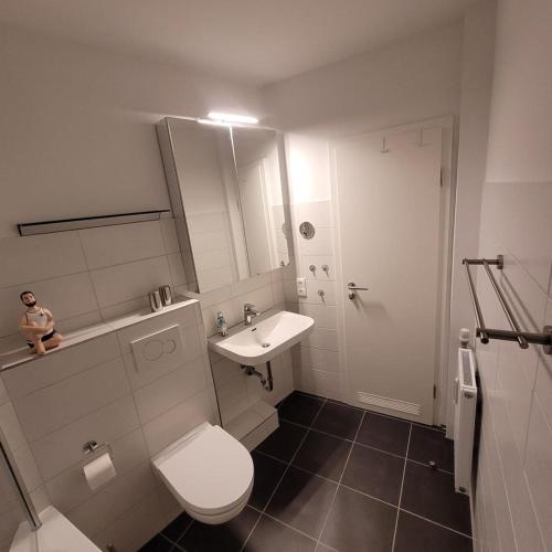 a bathroom with a white toilet and a sink at App Strandnest mit Meerbl mit Strandkorb am nahen Strand by Unsere Urlaubszeit in Grömitz