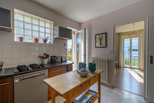 une cuisine avec une cuisinière et un comptoir dans l'établissement Villa Octave-Odette - 2 min de la plage, à Carnac