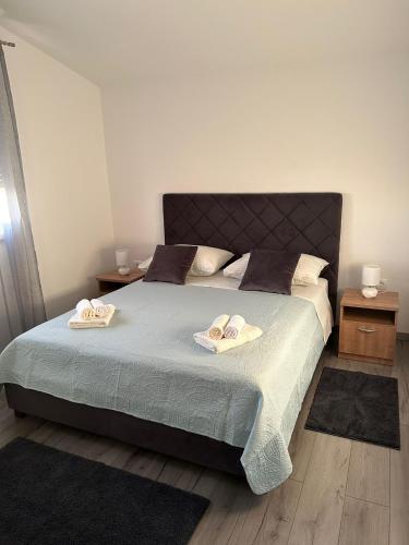 sypialnia z łóżkiem z dwoma kapeluszami w obiekcie Apartment Marko with a beautiful view of the sea w mieście Kaštel Sućurac