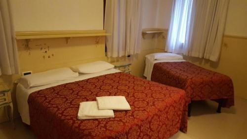 a hotel room with two beds with towels on them at Alloggi Gerotto Calderan 3 in Venice