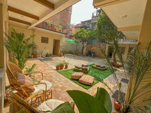 a courtyard with plants and chairs and a patio at The Melo pomelo courtyard. ( Right in between Thamel and basantapur durbar square) in Kathmandu