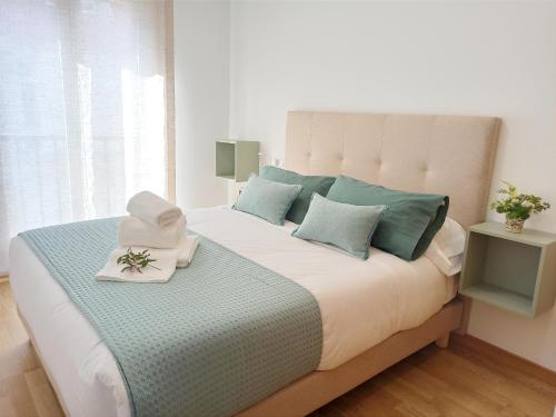 um quarto com uma cama grande e almofadas verdes e brancas em Aronda Cambados apartamento céntrico em Cambados