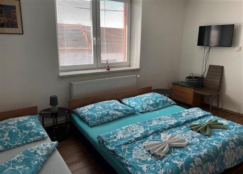 twee bedden in een slaapkamer met twee bogen erop bij Pension Sara in Hevlín