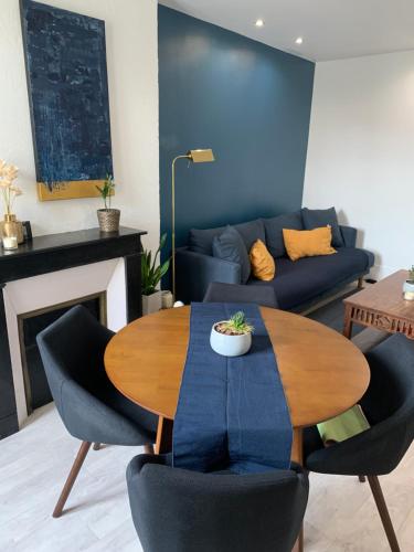 a living room with a table and a couch at Le Logis Cantilien Lamorlaye-Chantilly in Lamorlaye