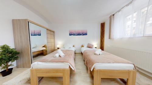 três camas num quarto com um espelho em Villa City Park em Košice