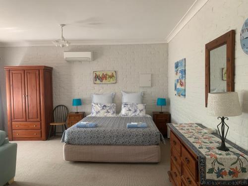 um quarto com uma cama e uma mesa com um candeeiro em Bentworth Lodge em Carramar