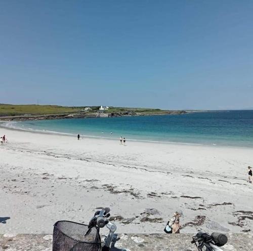 a sandy beach with a trash can and people on the beach at Swan Studio Haven in Lisdoonvarna