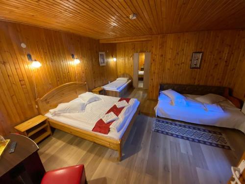 - une chambre avec 2 lits dans une pièce en bois dans l'établissement Pensiunea La Cristina, à Sinaia