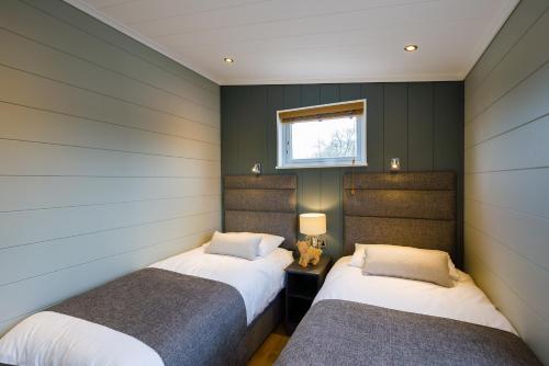 duas camas num quarto com paredes verdes em Berth 6 on Upton Lake, Upton-upon-Severn Home on Water em Upton upon Severn