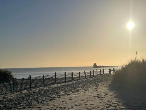 a person walking on a beach near the ocean at Vogelnest in Grömitz